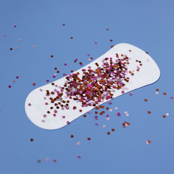 A-white-menstrual-pad-with-colorful-confetti-against-blue-background