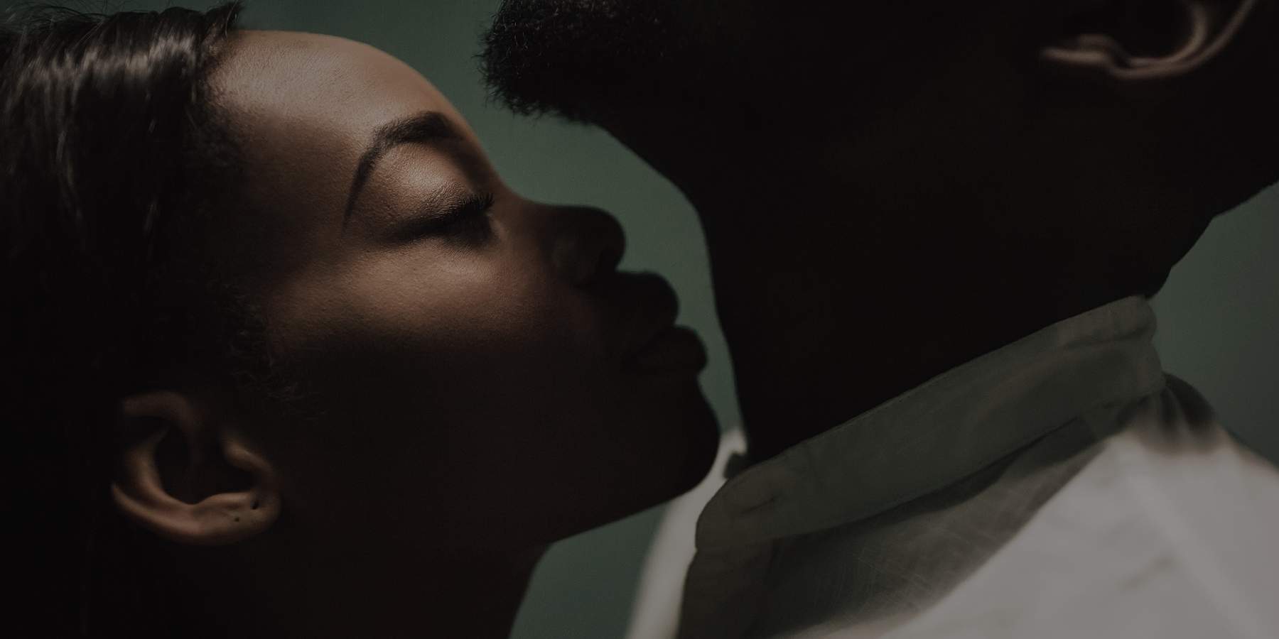 beautiful black couple closing to a kiss. girl smelling man's neck. kiss in the neck. fine art portrait of black lovers. smelling concept. love concept. perfumes smelling concept. aroma