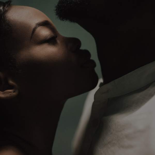 beautiful black couple closing to a kiss. girl smelling man's neck. kiss in the neck. fine art portrait of black lovers. smelling concept. love concept. perfumes smelling concept. aroma