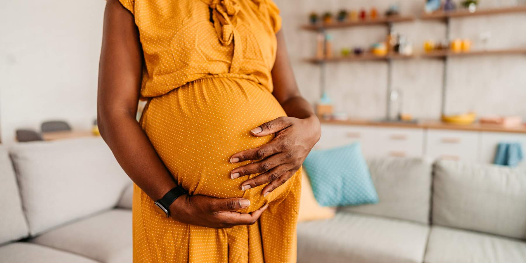 Beautiful-pregnant-Black-woman-holding-her-belly-enjoying-her-pregnancy