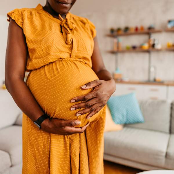 Beautiful-pregnant-Black-woman-holding-her-belly-enjoying-her-pregnancy