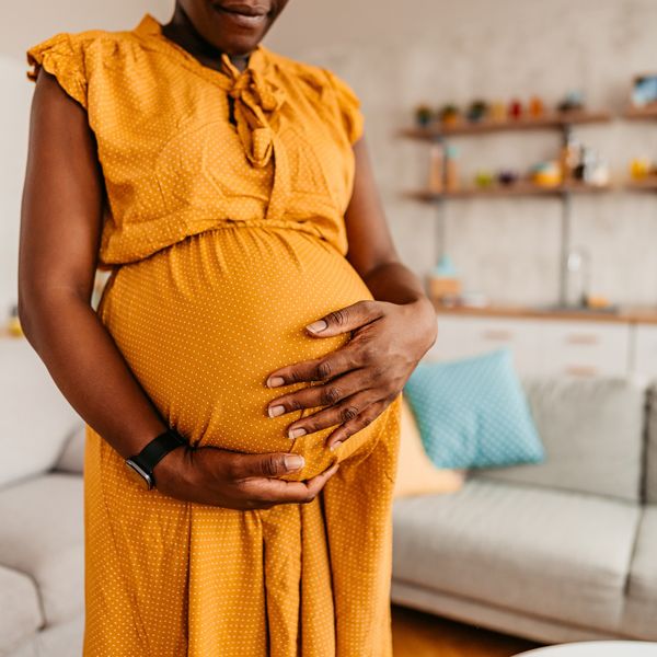 Beautiful-pregnant-Black-woman-holding-her-belly-enjoying-her-pregnancy