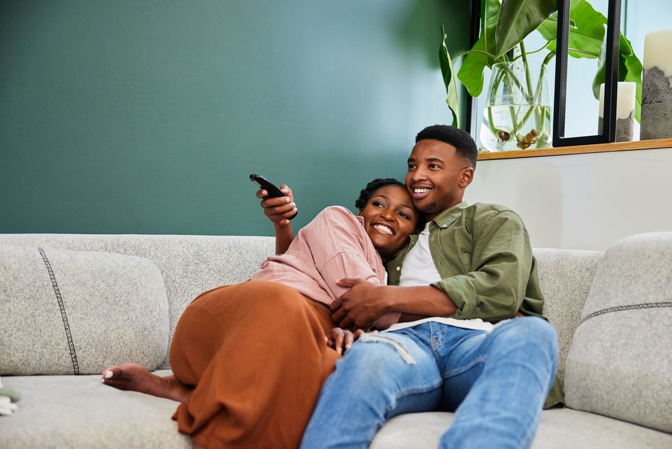 Black-couple-embracing-on-a-couch-as-they-watch-TV-together