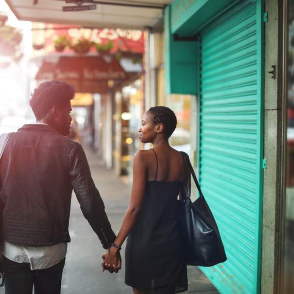 Black couple holding hands while walking down the street