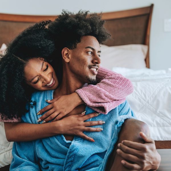 Black-couple-in-a-loving-embrace-wearing-bath-robes-by-a-bed