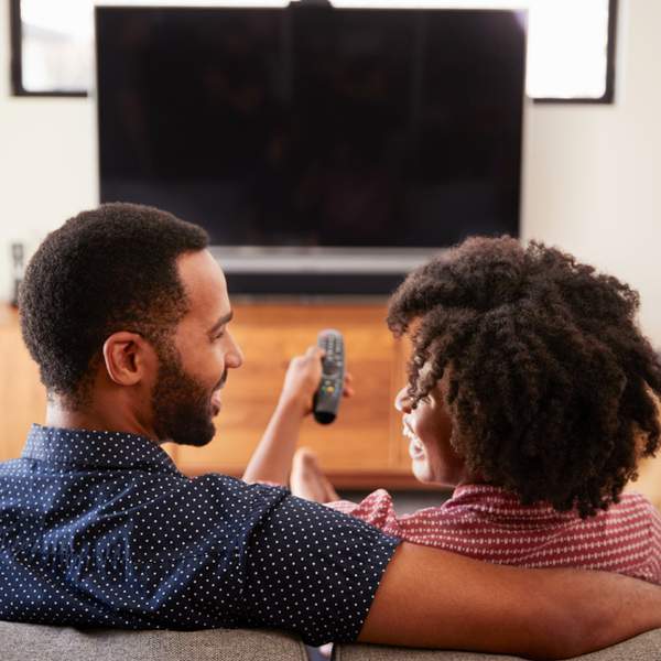 black-couple-remote-sitting-on-couch-tv