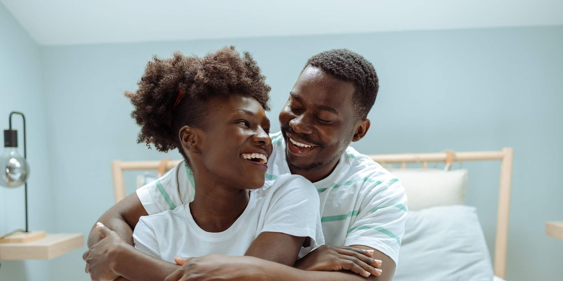 Black-couple-sharing-an-embrace-in-bed