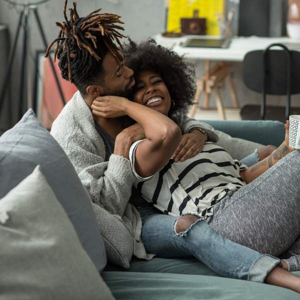 Black-couple-sharing-loving-embrace-on-a-couch