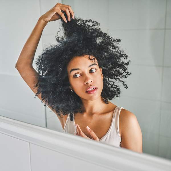 Black-woman-examining-her-hair-in-the-mirror