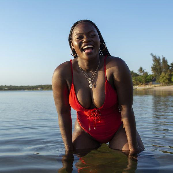 Black-woman-laughing-in-the-water-at-the-beach-in-swimsuit