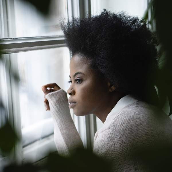 Black-woman-looking-out-of-her-window-searching-for-something-purpose