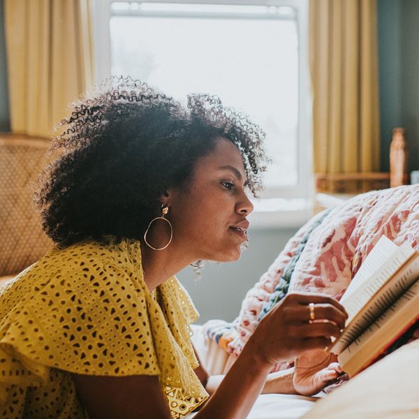 Black-woman-reading-in-cozy-bedroom-setting
