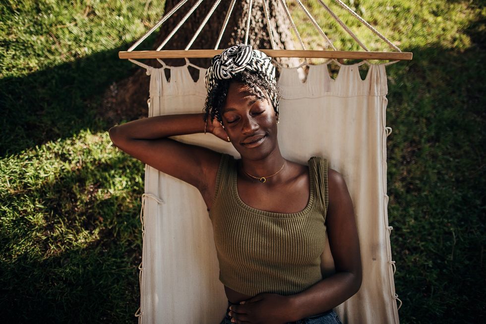 Black-woman-relaxing-in-hammock-outdoors-in-backyard