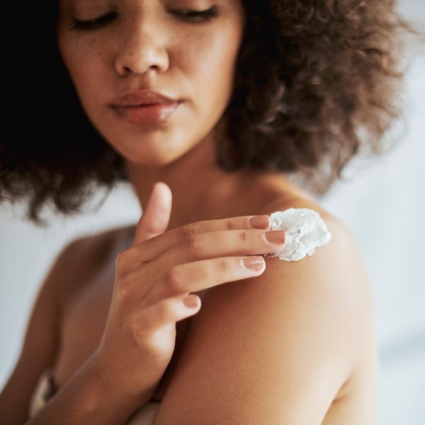 Black-woman-rubbing-moisturizer-cream-into-her-skin