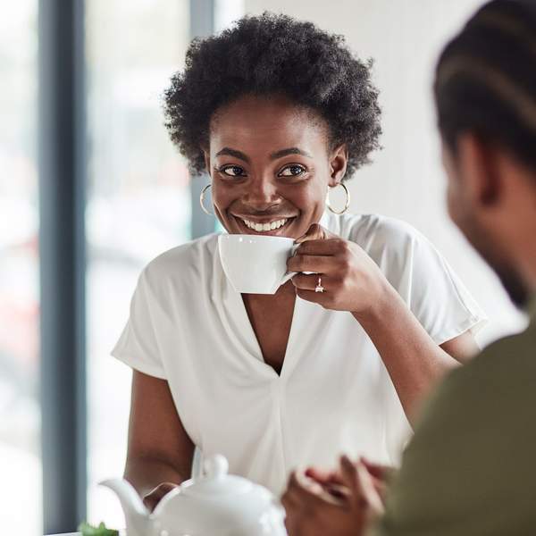 Black-woman-smiling-while-enjoying-a-coffee-date