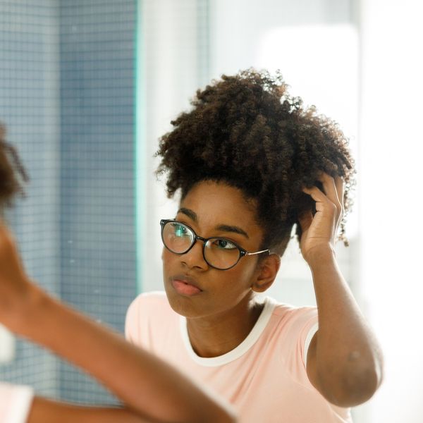 Black-woman-wearing-glasses-examining-her-Afro-in-the-mirror