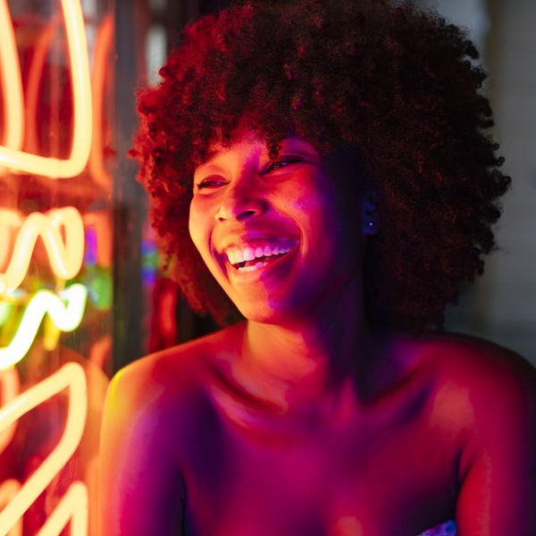 Black woman with an afro and tube top laughing