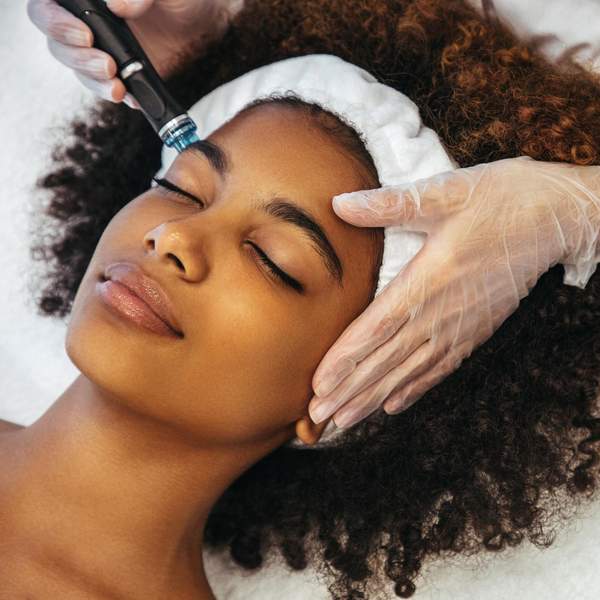 Close up of Black woman's face receiving facial treatment