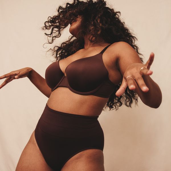 Confident young woman dancing in brown underwear, embracing body confidence and celebrating the crotch cleavage fashion trend