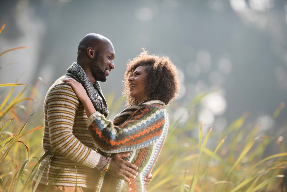 Couple-sharing-a-loving-gaze-and-embrace-in-meadow