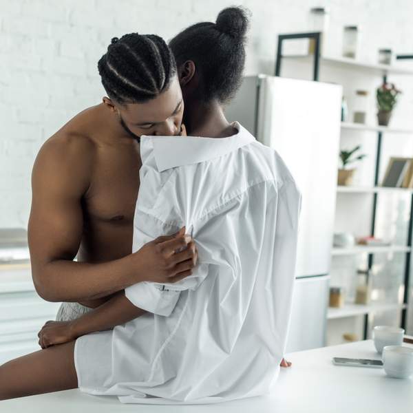 cropped image of african american lovers in morning at kitchen