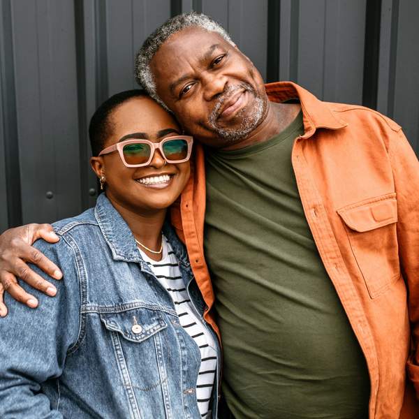 Father-daughter-share-loving-embrace-smiling-at-camera