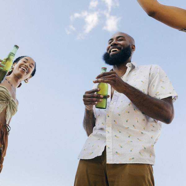 Group-Of-Friends Laughing And Drinking Beer At Rooftop Party