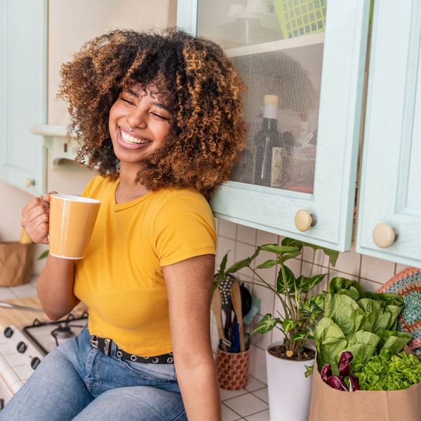 Happy black woman relaxing at home - Delightful female drinking waking up in the morning drinking tea