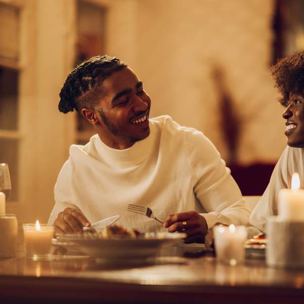 happy-young-Black-couple-having-romantic-dinner-date-night-at-home-by-candlelight