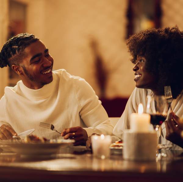 happy-young-Black-couple-having-romantic-dinner-date-night-at-home-by-candlelight