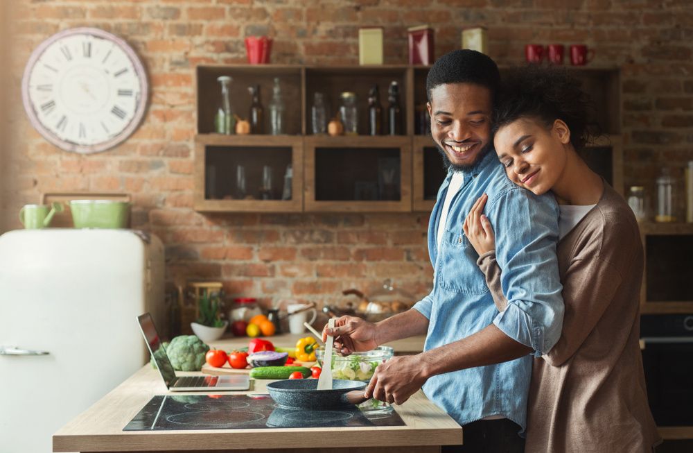 black-couple-hugging-cooking-in-kitchen