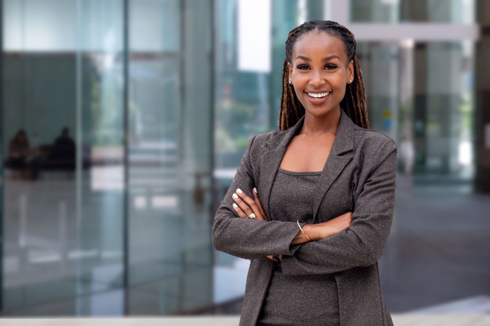 black-woman-locs-crossed-arms-professional-smiling