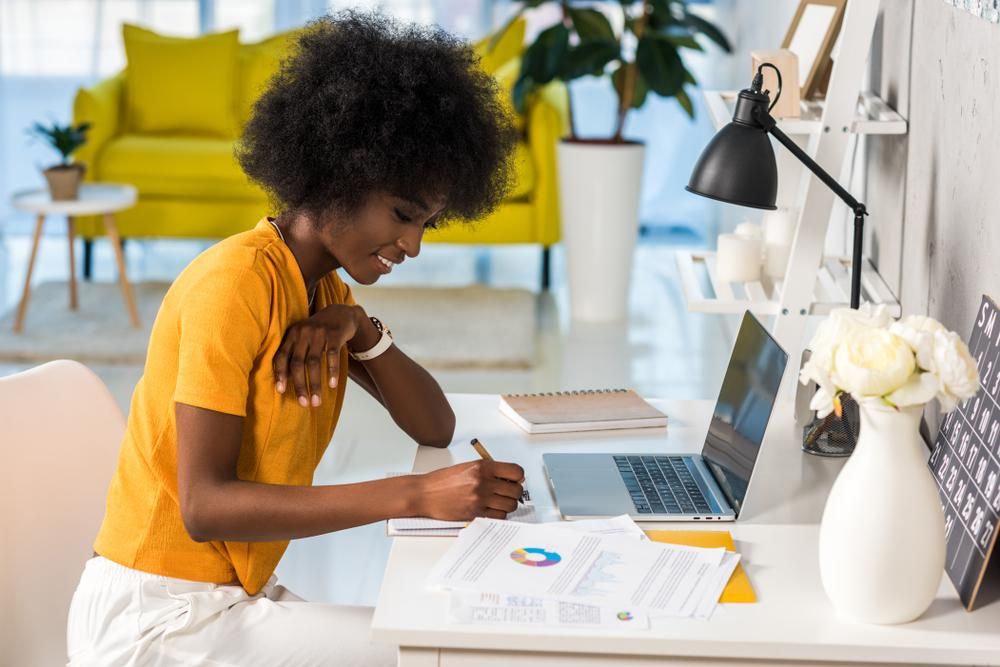 African-American woman in a yellow shirt and afro at work