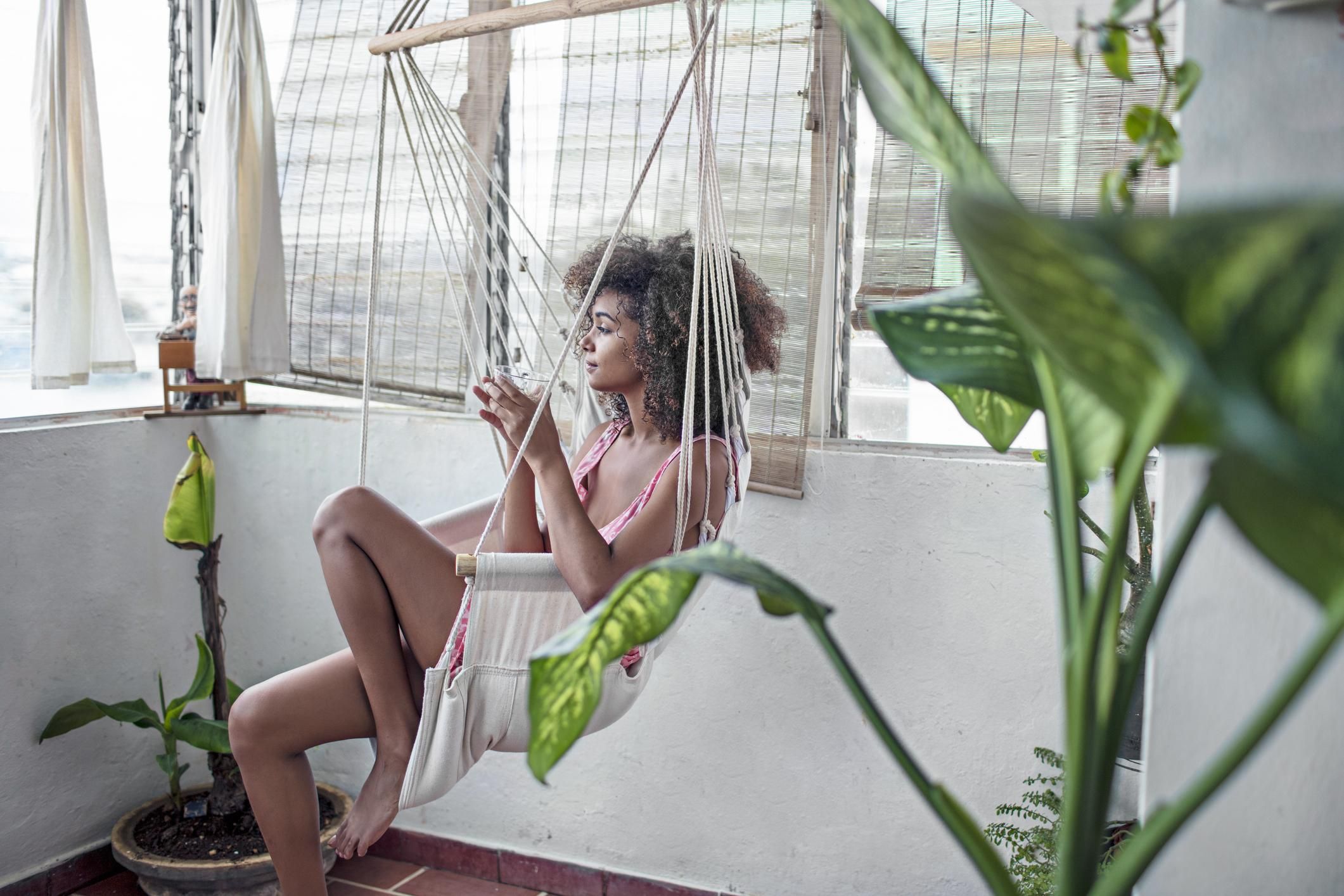 Black woman in a hammock drinking tea 