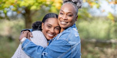 Mother and daughter smiling while they embrace each other