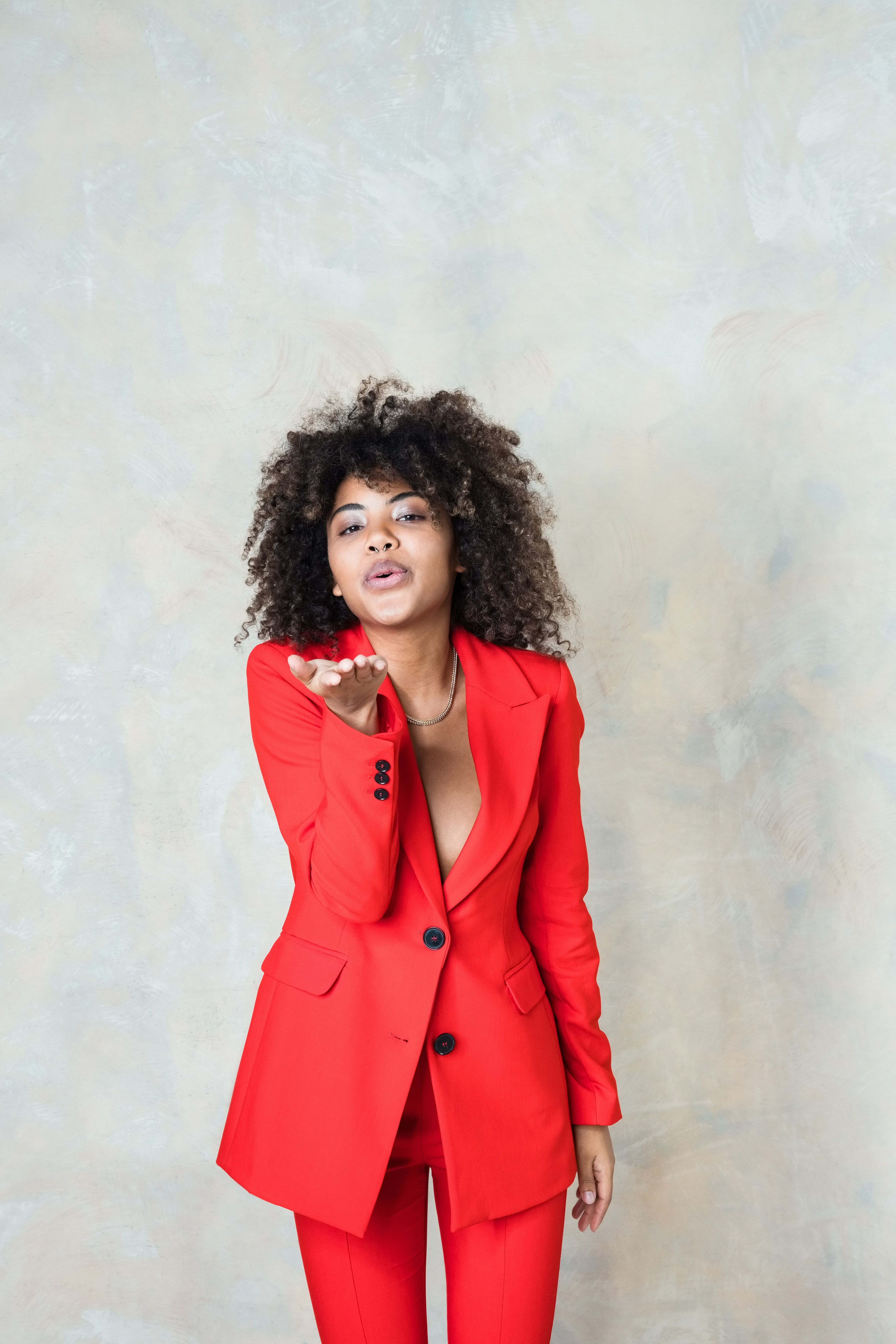 Young-woman-wearing-red-suit-blowing-a-kiss