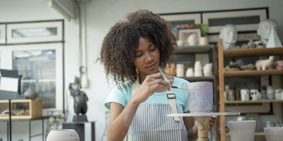 Young-Black-woman-creative-painting-pottery-in-class-trying-new-hobby