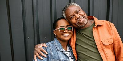 Father-daughter-share-loving-embrace-smiling-at-camera