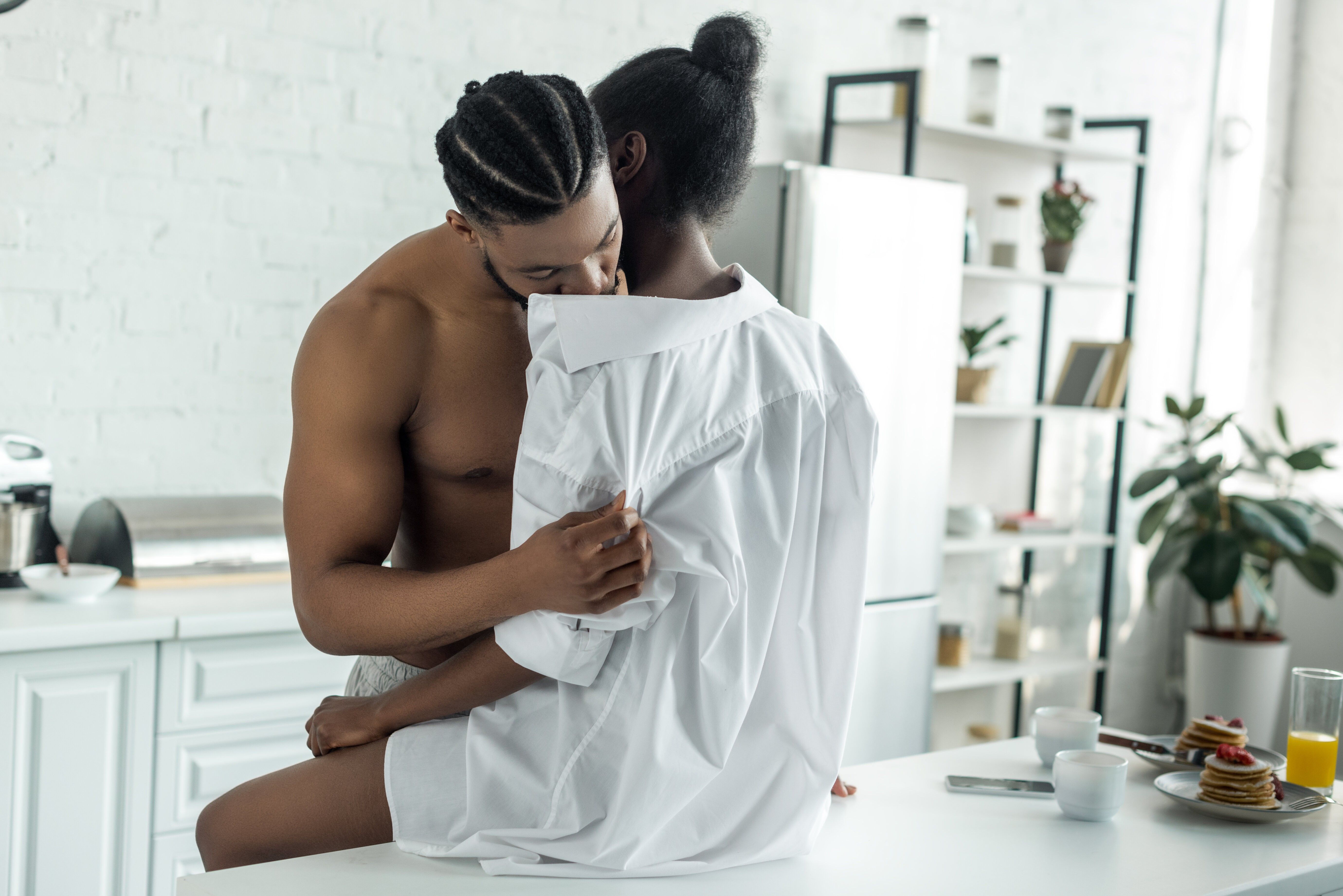 cropped image of african american lovers in morning at kitchen