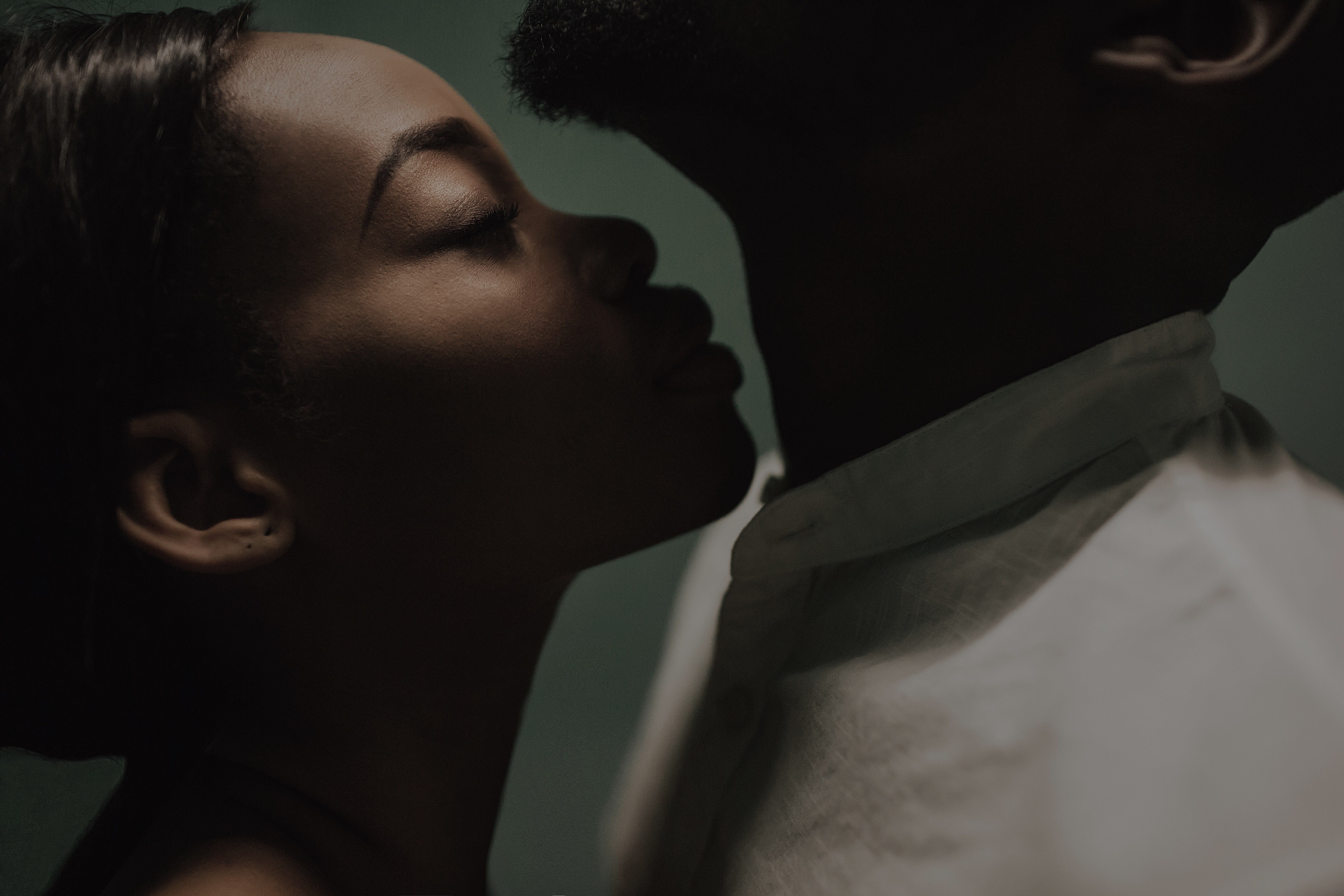 beautiful black couple closing to a kiss. girl smelling man's neck. kiss in the neck. fine art portrait of black lovers. smelling concept. love concept. perfumes smelling concept. aroma  