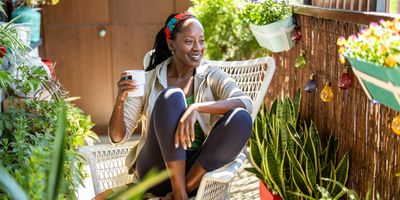 Mature woman enjoying quiet time outdoors on her balcony, representing life after menopause with peace and strength