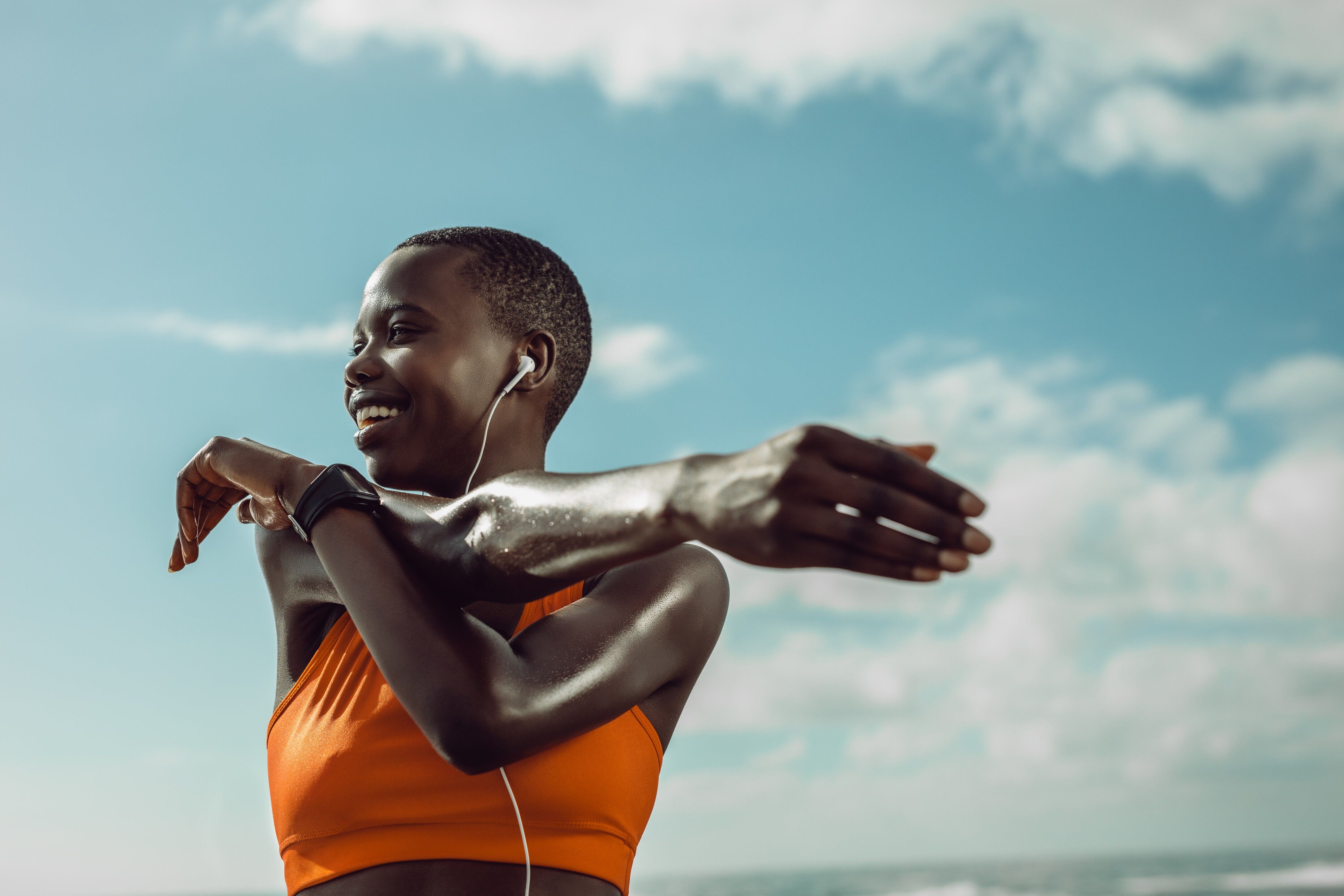 Black woman stretching at the beach during a morning workout during The Great Lock In reset