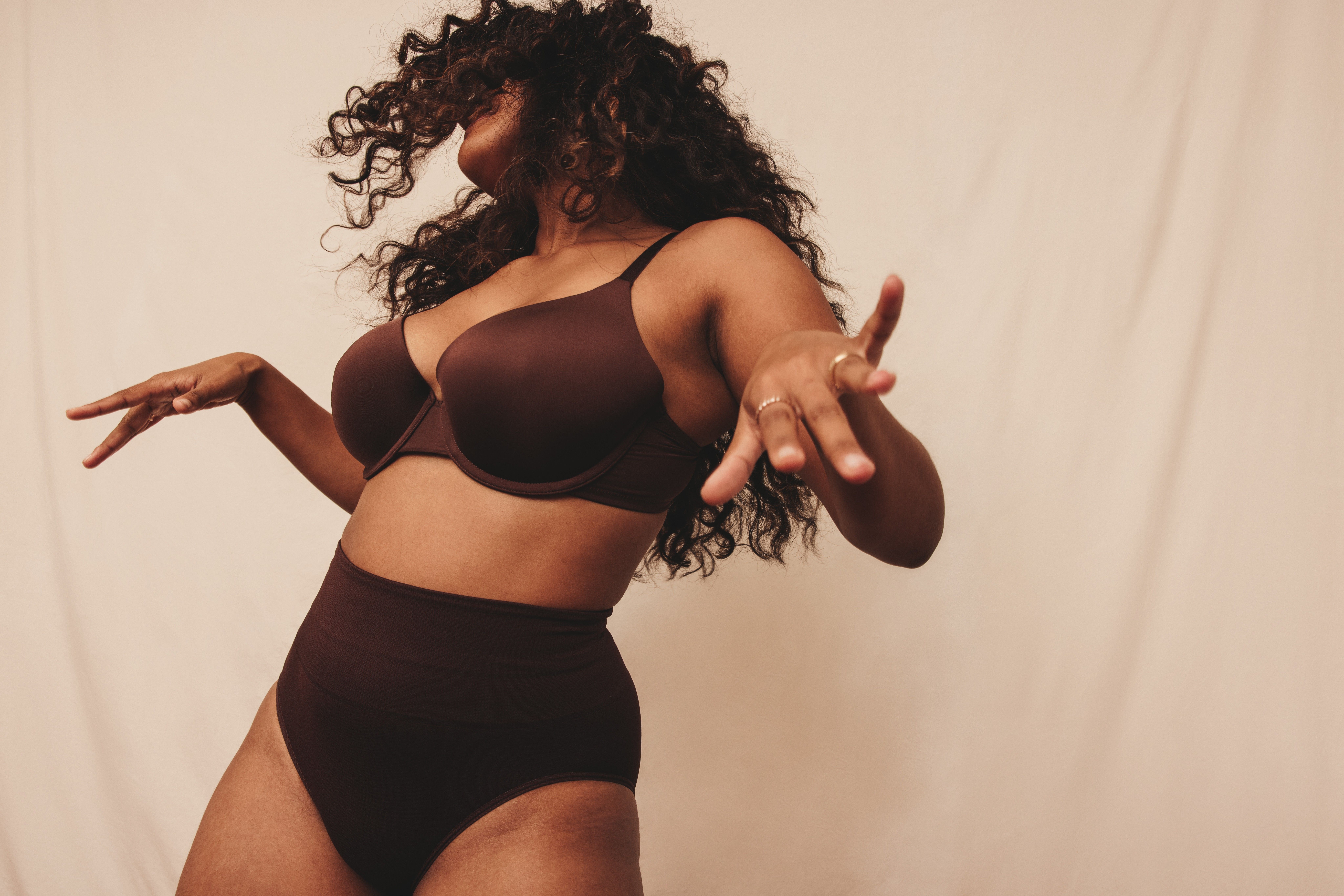 Confident young woman dancing in brown underwear, embracing body confidence and celebrating the crotch cleavage fashion trend