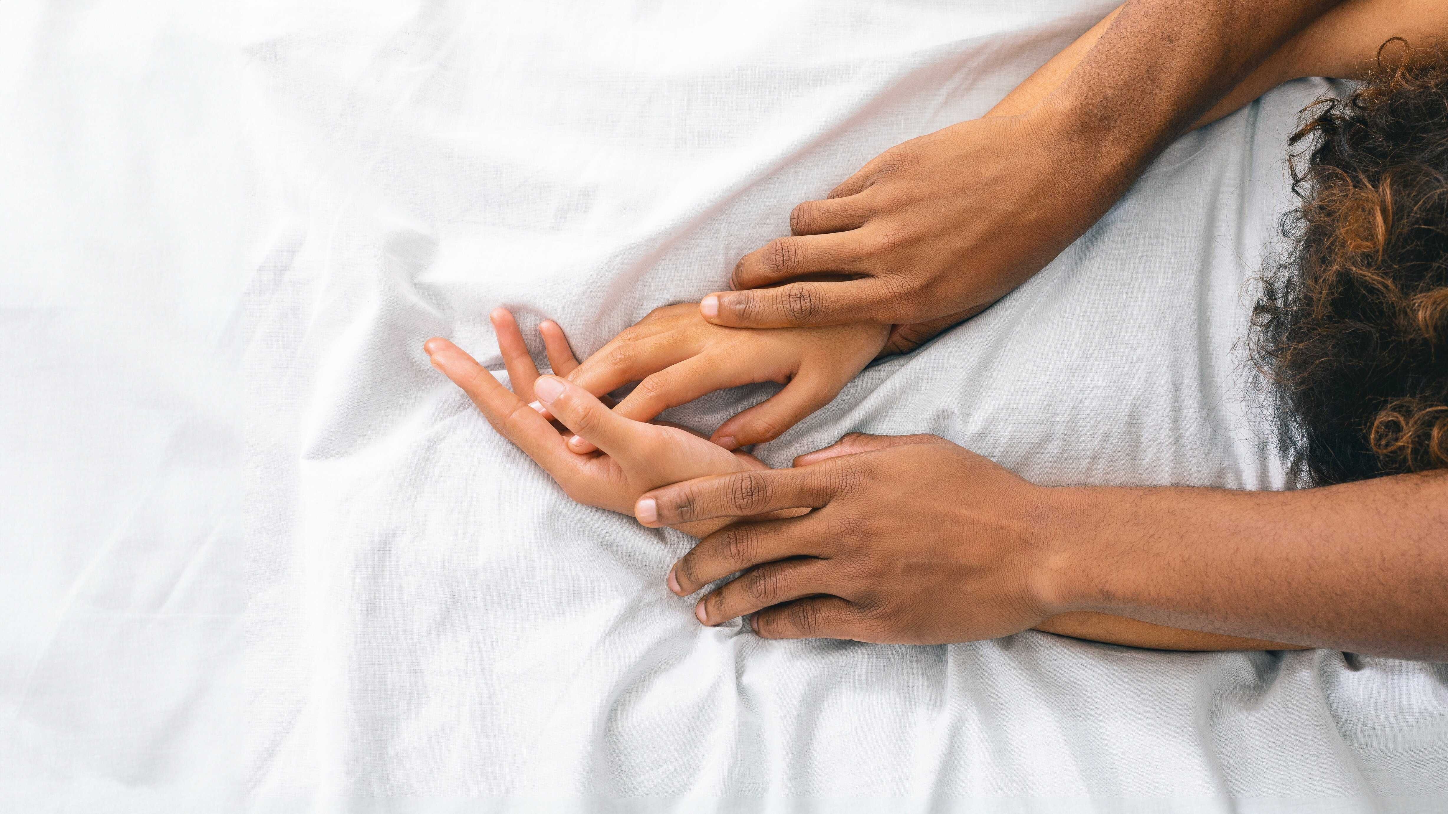 Black man and woman enjoying sexual foreplay in bed, free space