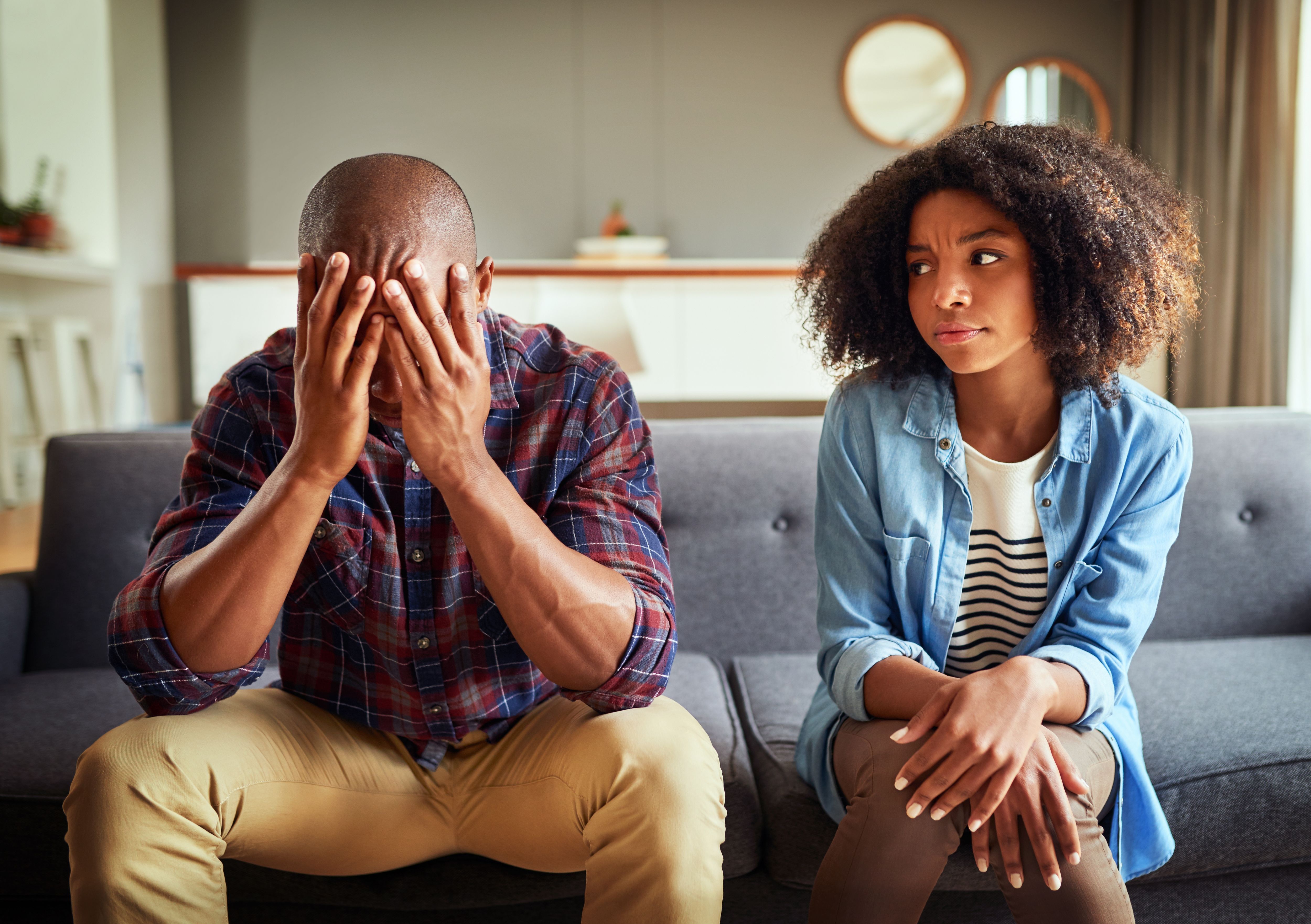 Apartment, couple and arguing in living room on couch for disagreement, problems and unhappy. Relationship, people and conflict or upset with confrontation at lounge on sofa with regret and toxic