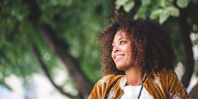 thoughtful-black-woman-with-curly-hair-looking-away-smiling