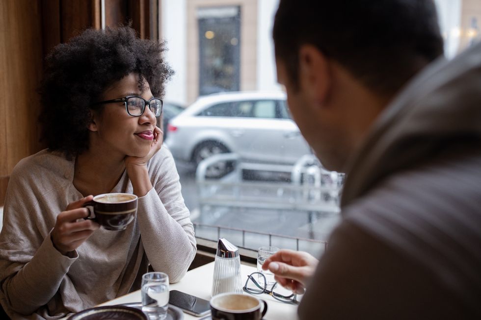 interracial-couple-enjoying-coffee-and-intimacy-in-a-cafe