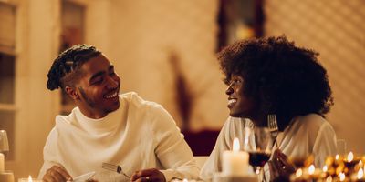 happy-young-Black-couple-having-romantic-dinner-date-night-at-home-by-candlelight