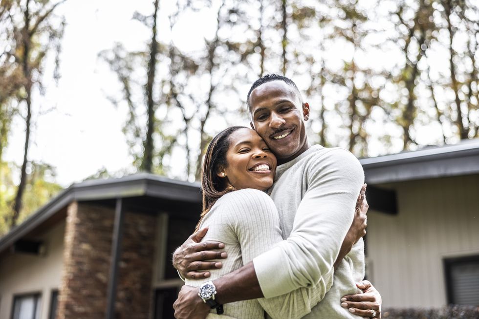 Loving-couple-embracing-each-other-house-in-the-background