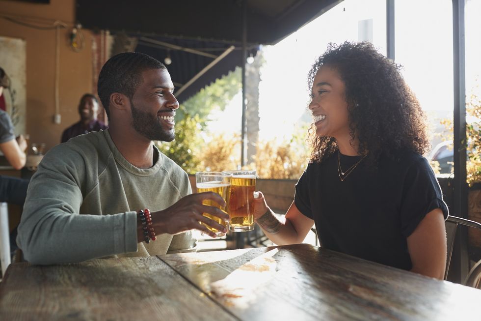 Man-and-woman-cheering-to-each-other-with-their-glasses-of-beer